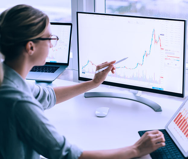 A female looking at a chart on a screen. 